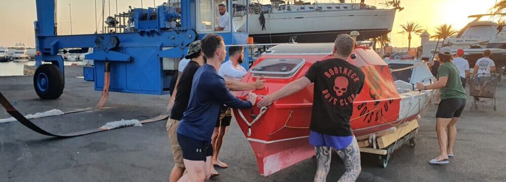 Atlantic Dagger pushing their boat on a wheeled cradle in Pasito Blanco marina
